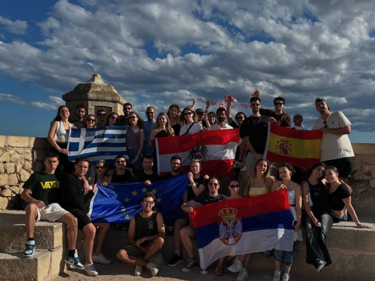 Young people from several European countries holding their national flags outdoors